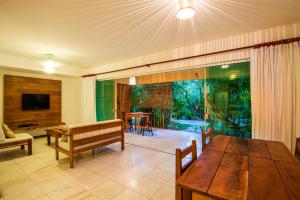 a living room with a wooden table and a couch at Apartamento 2 quartos no Imbassai Breezes in Imbassai