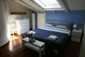 Un dormitorio azul con una cama con toallas. en La Pietra del Golfo, en La Spezia