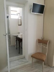 a bathroom with a mirror and a chair and a sink at Villa la Fonte in Marina di Pietrasanta