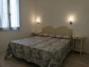 a bedroom with a bed and two night stands at Villa la Fonte in Marina di Pietrasanta