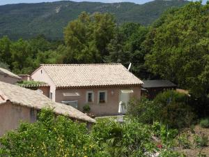 una piccola casa con una montagna sullo sfondo di Lou Relambi a Bagnols-en-Forêt