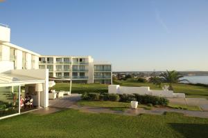a view of a building with a patio and grass at Memmo Baleeira - Design Hotels in Sagres