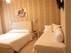 a bedroom with two beds and a picture on the wall at Hotel Bridge in Venice
