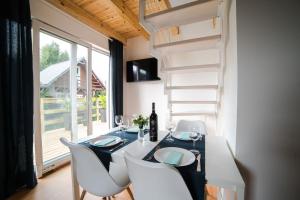 a dining room with a table and chairs and a ladder at Domki Borys in Jastrzębia Góra
