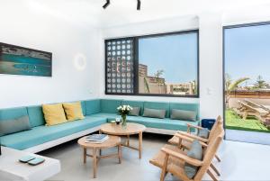 sala de estar con sofá azul y mesa en Fos Villa, a Luxe House with Private Heated Pool, en Galatás