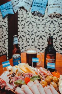 a plate of food on a table with two bottles of beer at Tango de Mayo Hotel in Buenos Aires