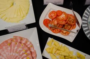 a table with plates of food with tomatoes and cheese at Tango de Mayo Hotel in Buenos Aires