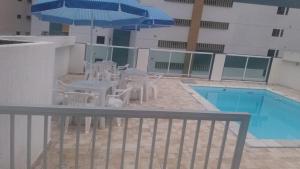 a patio with a table and chairs next to a pool at Pousada Beira Mar in Recife