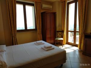 a bedroom with a bed with two towels on it at Hotel Belvedere in Alice Bel Colle