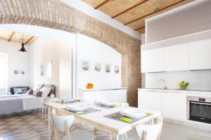 een keuken en een woonkamer met een tafel en stoelen bij Lilli Vatican White Domus in Rome