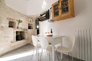 a dining room with a white table and white chairs at Casa del sole in Ceglie Messapica