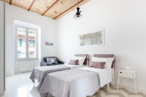 two beds in a room with white walls at Lilli Vatican White Domus in Rome
