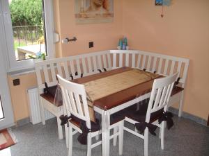 ハノーファーにあるPrivate Room with Breakfastのダイニングルームテーブル(白い椅子、木製テーブル付)