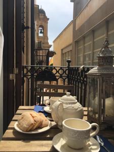 a table with cups and plates of food on a balcony at Il Profumo del Sale in Marsala