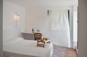 um quarto branco com uma cama, uma mesa e cadeiras em Villa Canisello em Noto