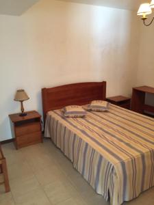 ein Schlafzimmer mit einem Bett mit zwei Kissen darauf in der Unterkunft Casa Circular Norte in Nazaré