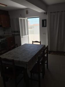 einen Tisch und Stühle in einer Küche mit Fenster in der Unterkunft Casa Circular Norte in Nazaré