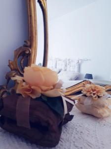 een bed met een spiegel en bloemen erop bij Appartamenti Mori in Belluno