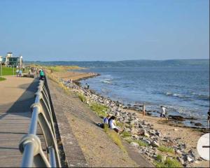 a group of people on the beach near the water at Beach Front Ground Floor Apartment in Llanelli