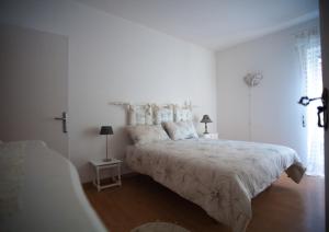 a white bedroom with a large bed and a window at Appartamenti Mori in Belluno