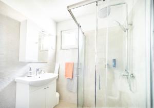 W łazience znajduje się szklana kabina prysznicowa i umywalka. w obiekcie Apartmani Ada 1 w mieście Povlja