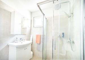 a bathroom with a glass shower and a sink at Apartmani Ada 1 in Povlja