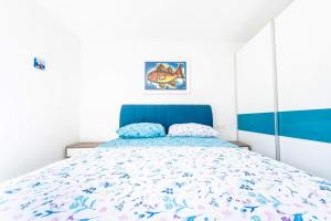 Schlafzimmer mit einem Bett mit blauem Kopfteil in der Unterkunft Apartmani Ada 1 in Povlja