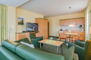 ein Wohnzimmer mit einem Sofa und einem Tisch in der Unterkunft Am Weststrand Aparthotel Kühlungsborn in Kühlungsborn