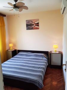 1 dormitorio con 1 cama con sábanas azules y 2 lámparas en Apartments Eli, en Korčula