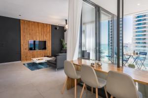 a living room with a table and chairs and a couch at Hayarkon 29 - Next Royal Beach in Tel Aviv