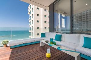 a living room with a white couch and a view of the ocean at Hayarkon 29 - Next Royal Beach in Tel Aviv