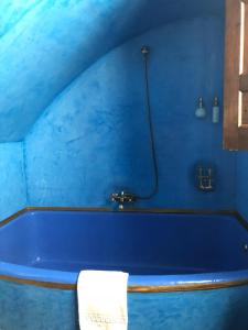 a blue bathroom with a bath tub with a towel at Hotel Casa Imperial in Seville