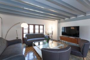a living room with couches and a tv at Gran H La Marina in Altea