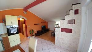 kuchnia i salon z kamienną ścianą w obiekcie Guest House Ilic w mieście Loborika