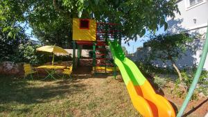 plac zabaw ze zjeżdżalnią na podwórku w obiekcie Guest House Ilic w mieście Loborika