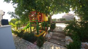 plac zabaw w ogrodzie obok drzewa w obiekcie Guest House Ilic w mieście Loborika