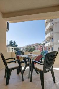 un tavolo e sedie su un balcone con vista di Apartmani Agape a Petrovac na Moru
