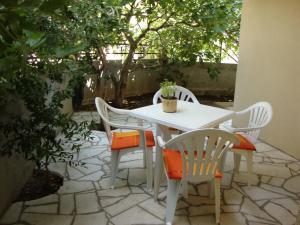 a white table and chairs on a patio at Apartmani Agape in Petrovac na Moru