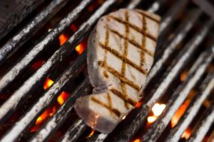 a piece of food is cooking on a grill at Auberge Val Moureze Hôtel & Spa in Mourèze