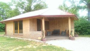 eine kleine Holzhütte mit Veranda und Tisch in der Unterkunft Klintis in Jaungulbene