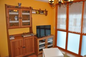 ein Wohnzimmer mit einem TV und einem Entertainment-Center in der Unterkunft Apartamento en Isaba (NAVARRA) in Isaba