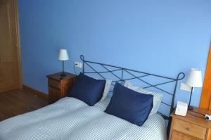 Apartamento en Isaba (NAVARRA) في إيسابا: غرفة نوم زرقاء مع سرير ووسادتين زرقاوين