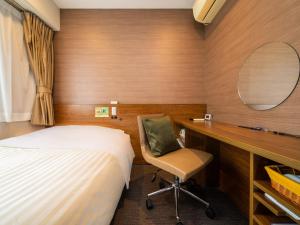 熊本市にあるNatural Hot Spring SUPER HOTEL Kumamoto Chamber of Commerceのベッドと机と椅子のある寝室