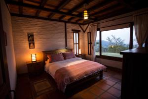 a bedroom with a bed and a large window at Eucaliptus Spa Resort in Dapa