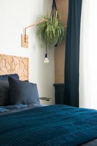オーにある-LA CORDIALITÉ-のベッドルーム1室(青い掛け布団、植物付)
