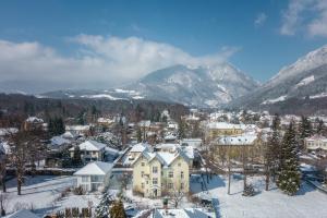 Landhaus Blauer Spatz Reichenau an der Rax في رايشناو: مدينة مغطاة بالثلج مع جبال في الخلفية