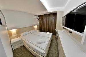 a hotel room with a bed and a flat screen tv at Apartment OneClickRent_04 - Smart House in Chişinău