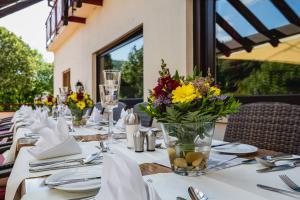 Una mesa larga con flores en un jarrón. en Hotel - Restaurant Bastenhaus, en Dannenfels