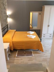 a bedroom with a yellow bed and a mirror at La casa nel verde in Castelmezzano