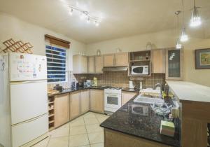 塔馬蘭的住宿－Villa Bayswater，厨房配有木制橱柜和白色家电